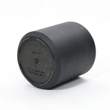 A black cylindrical drum with a flat top, ideal for planters, features an embossed instruction that reads, For outdoor use. Drill hole here. Crafted to be durable, it promises long-lasting performance in any outdoor setting.