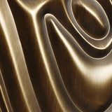 A close-up of a smooth, shiny bronze sculpture reveals swirling, curved grooves crafting a mesmerizing 3D abstract design perfect for modern home decor.