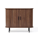The Aria by LuxenHome is a Mid-Century Modern accent cabinet featuring tambour doors and two black metal handles. It boasts a dark oak finish with a curved front atop four slender black legs, enhancing its elegant design.