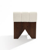 The Lorenzo boucle upholstered wood frame armless accent chair by LuxenHome features a dark wooden base with three distinct columns and a white cushioned top. The geometric cut-out base adds mid-century allure, while high-density foam ensures comfort. Presentation in front of a plain white background.
