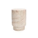 A cylindrical, light-colored stool with a ribbed design crafted from MgO material embodies both indoor and outdoor aesthetics. Its textured, travertine-style design complements any white background effortlessly.
