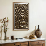 A wooden console with decorative items and a coffee table book sits beneath a framed piece of modern home decor. This gold metal abstract wall decor adds an artistic touch to the light-colored wall.