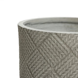 Close-up of a round, textured ceramic planter showcasing a herringbone pattern in light grey tones. Its modern minimalist design is accentuated by the visible interior from the top edge.