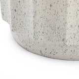 Close-up of the lower portion of a round, cement object with a speckled gray pattern and a slightly textured surface—perfect as modern outdoor decor—set against a white background.