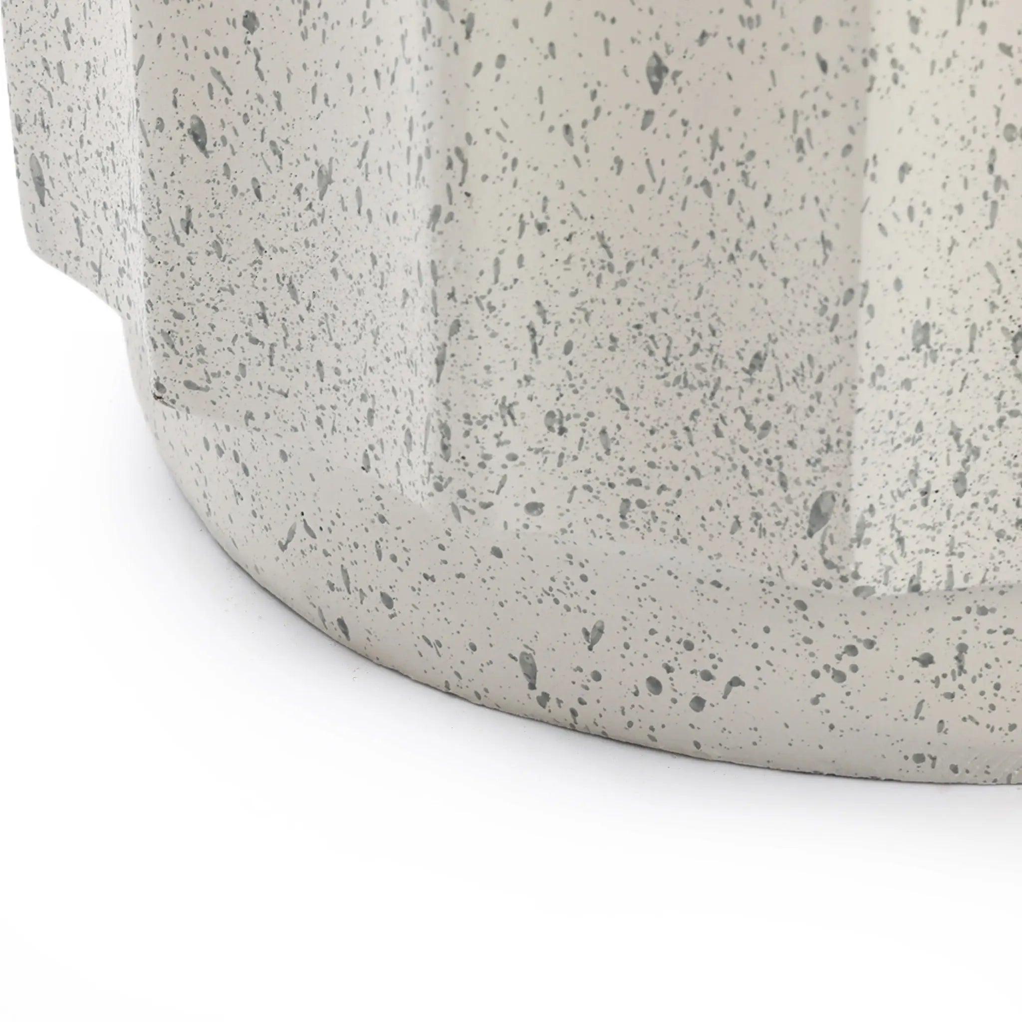 Close-up of the lower portion of a round, cement object with a speckled gray pattern and a slightly textured surface—perfect as modern outdoor decor—set against a white background.