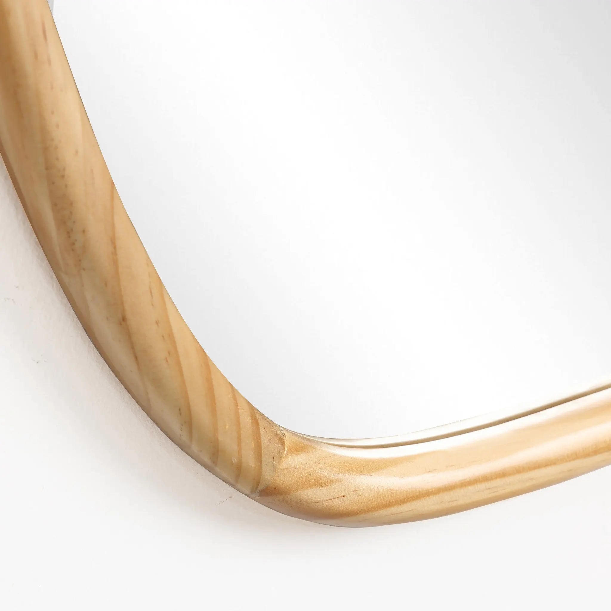 Close-up of an irregular-shaped wall mirror with a natural pine frame, highlighting the edge against a white background, perfect for home decoration.