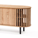 Mid-century modern TV cabinet with an oval shape, featuring slatted sides and a smooth surface. The light wood grain finish beautifully contrasts the black metal legs, while its sleek sliding door design adds both style and functionality.