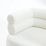 A close-up of the Tia ivory barrel accent chair by LuxenHome reveals a modern look with rounded corners, cylindrical armrests, and wooden ball legs. Its soft fabric texture enhances the double bolster backrest, and its clean, minimalist lines express contemporary style.
