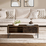 A modern living room with a beige sofa, patterned pillows, a mid-century modern wood coffee table with storage and decor, a light rug, and two abstract wall art pieces.