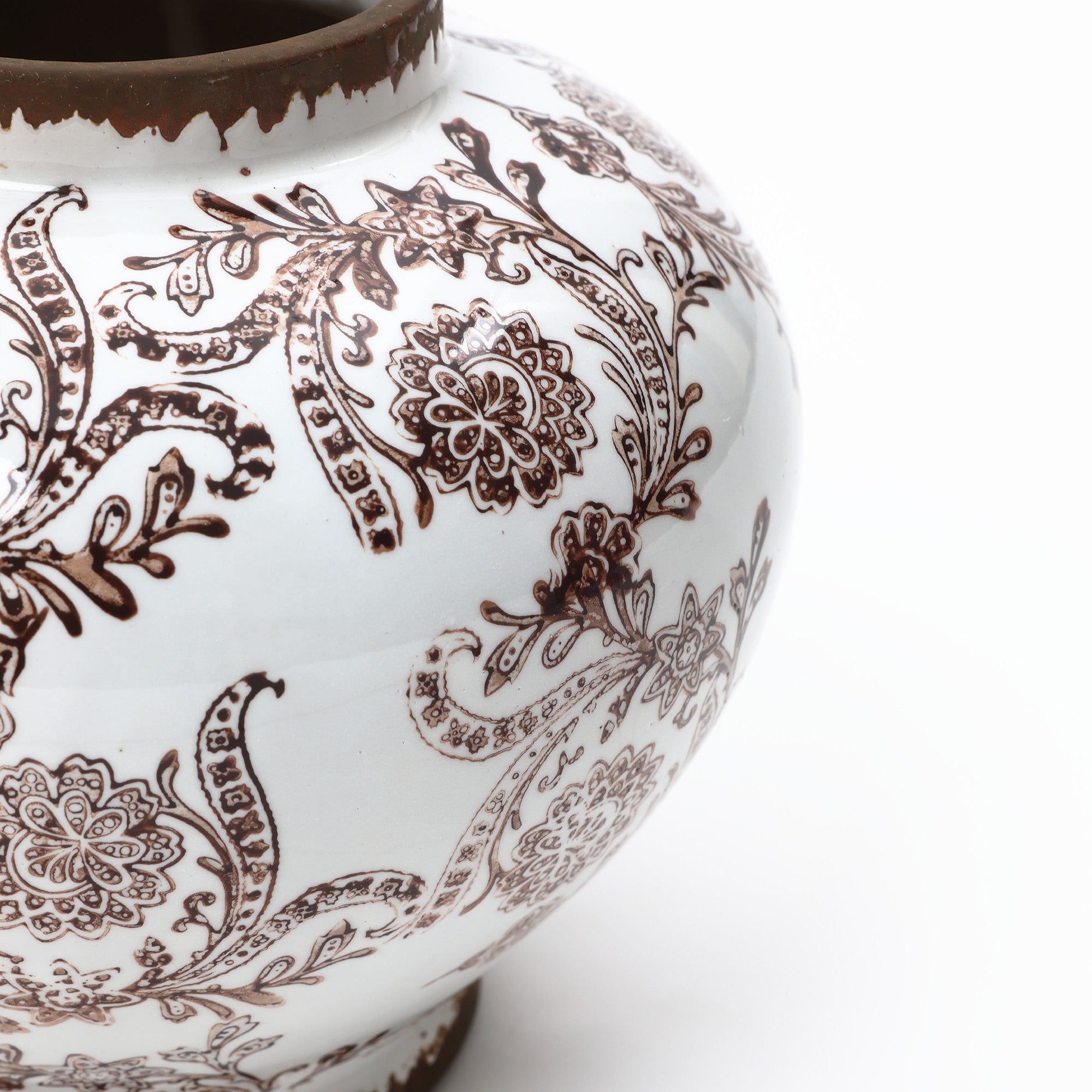 Close-up of an waterproof ceramic vase featuring intricate brown floral and paisley patterns.