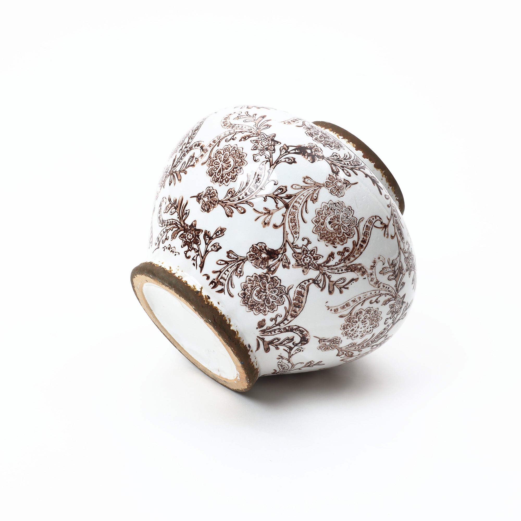 A white ceramic vase with intricate brown floral patterns, positioned on its side against a plain white background.