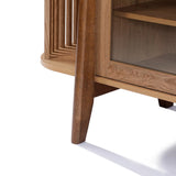 The Miko sideboard server cabinet by LuxenHome features solid wood legs, a glass door, vertical side slats, and tapered legs. Its light brown finish and open interior shelf embody mid-century modern design.