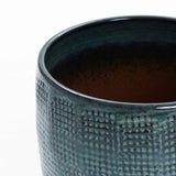 Close-up of a LuxenHome Marina gray glazed planter, 11.22 h, with a textured ceramic surface and grid-like design. The round-bottom reveals its interior in gradient darker shades, offering an intriguing look.