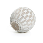 A LuxenHome 11.81 high round planter features a geometric feather-like pattern with alternating white and beige segments. Its bottom has an opening with a circular detail, indicating its made from durable MgO and fiberglass.