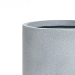 Close-up of a gray, cylindrical concrete planter crafted from high-quality MGO material, featuring a slightly textured surface and showing the top edge and an empty interior against a white background.