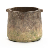 A rustic, cylindrical clay pot with two small handles, displaying a weathered, earthy texture and a slightly uneven rim, reminiscent of a ginger root brown vase.