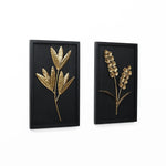 Two black frames showcase brass botanical sculptures: one with elongated leaves and the other with clusters of small flowers, artfully curated as wall art against a white backdrop. Perfect for adding a touch of sophistication to any interior design scheme.