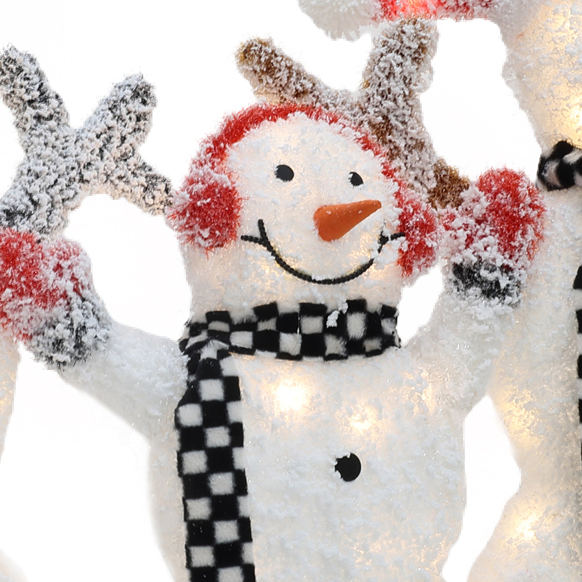 A charming snowman decoration with red earmuffs, a black and white checkered scarf, and arms raised, covered in artificial snow—perfect for your outdoor Christmas decor.