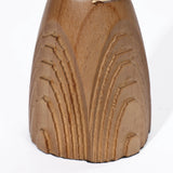 Handcrafted wooden sculpture with carved, curved geometric patterns on a smooth, rounded surface, reminiscent of elegant rattan design.