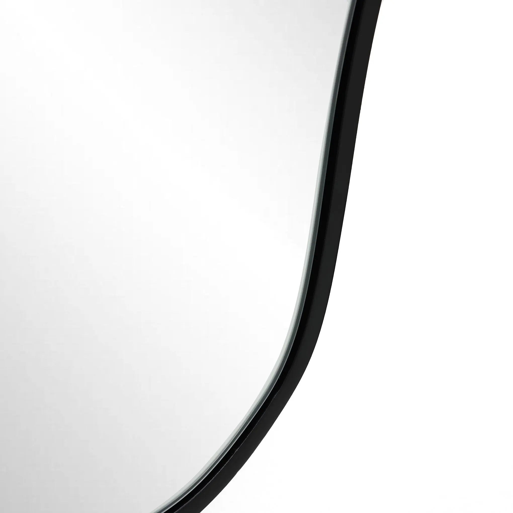The curved edge of an asymmetrical mirror complements the sleek, frameless design against a plain background, embodying modern minimalism.