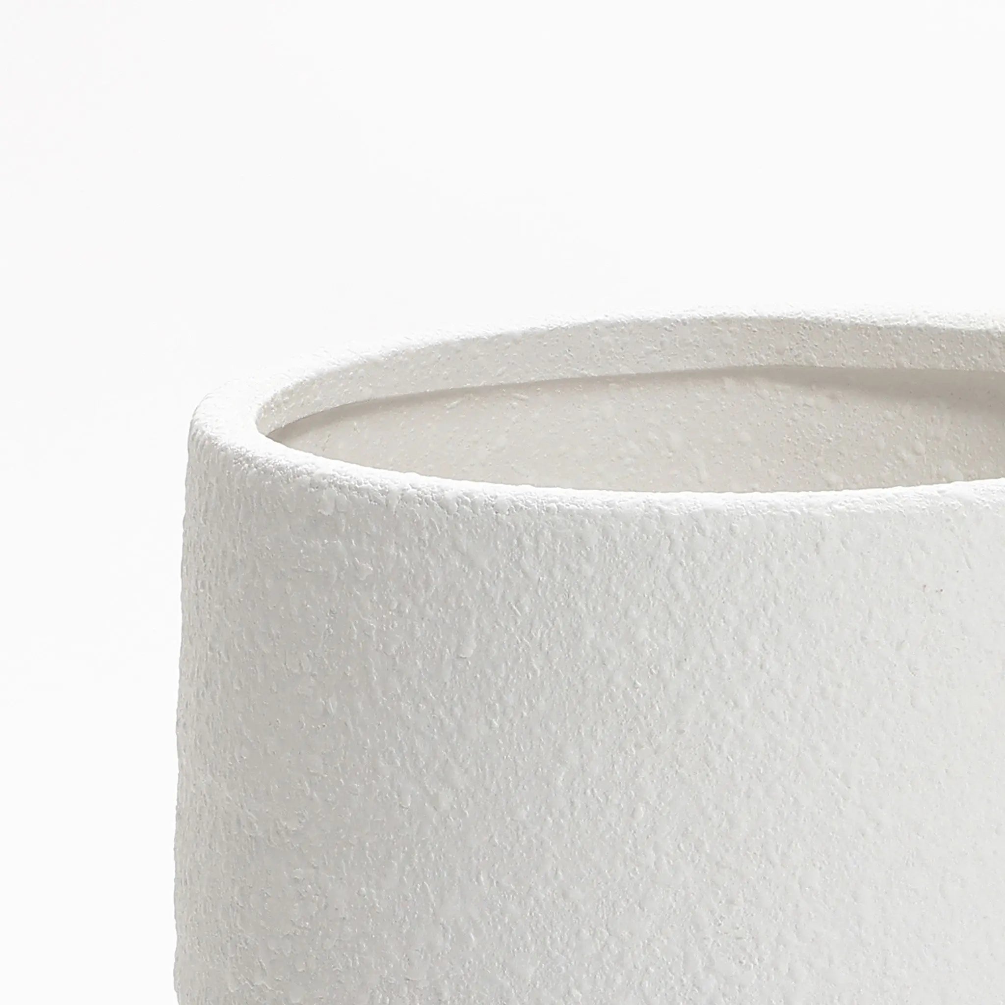 Close-up of a textured, white cylindrical object resembling a 12-inch tall terracotta vase, featuring a smooth interior and slightly curved edge against a plain white background.
