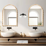 Double vanity setup featuring two rubberwood round sinks complemented by 34-inch arch mirrors with scalloped edge framing, and central lighting. Neutral tones and small plants enhance the minimalist aesthetic.