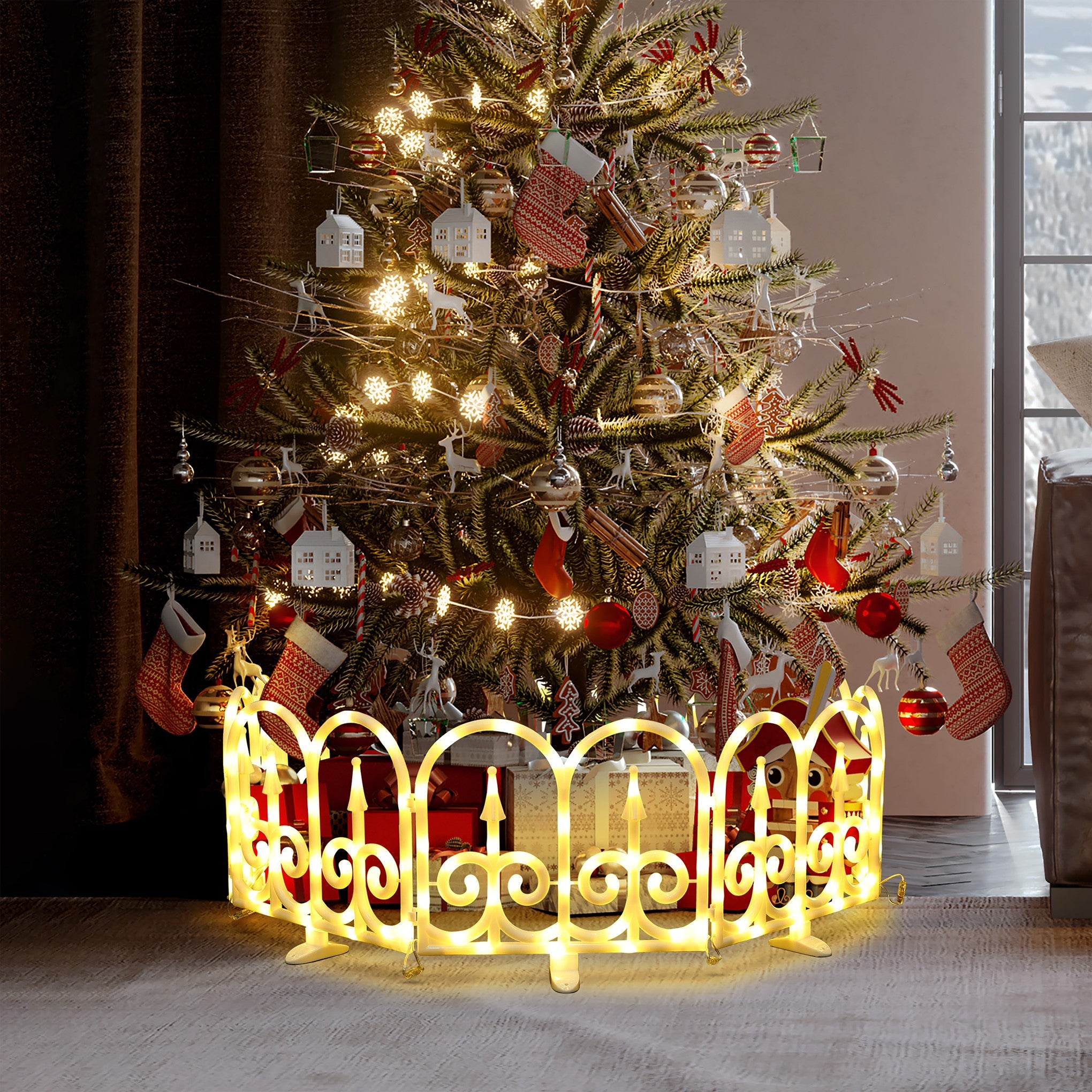 Decor christmas tree stands indoors with ornaments, stockings, illuminated led fence around its base.