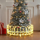 Decor christmas tree with ornaments, lights stands behind glowing led fence, with wrapped presents placed to the side.