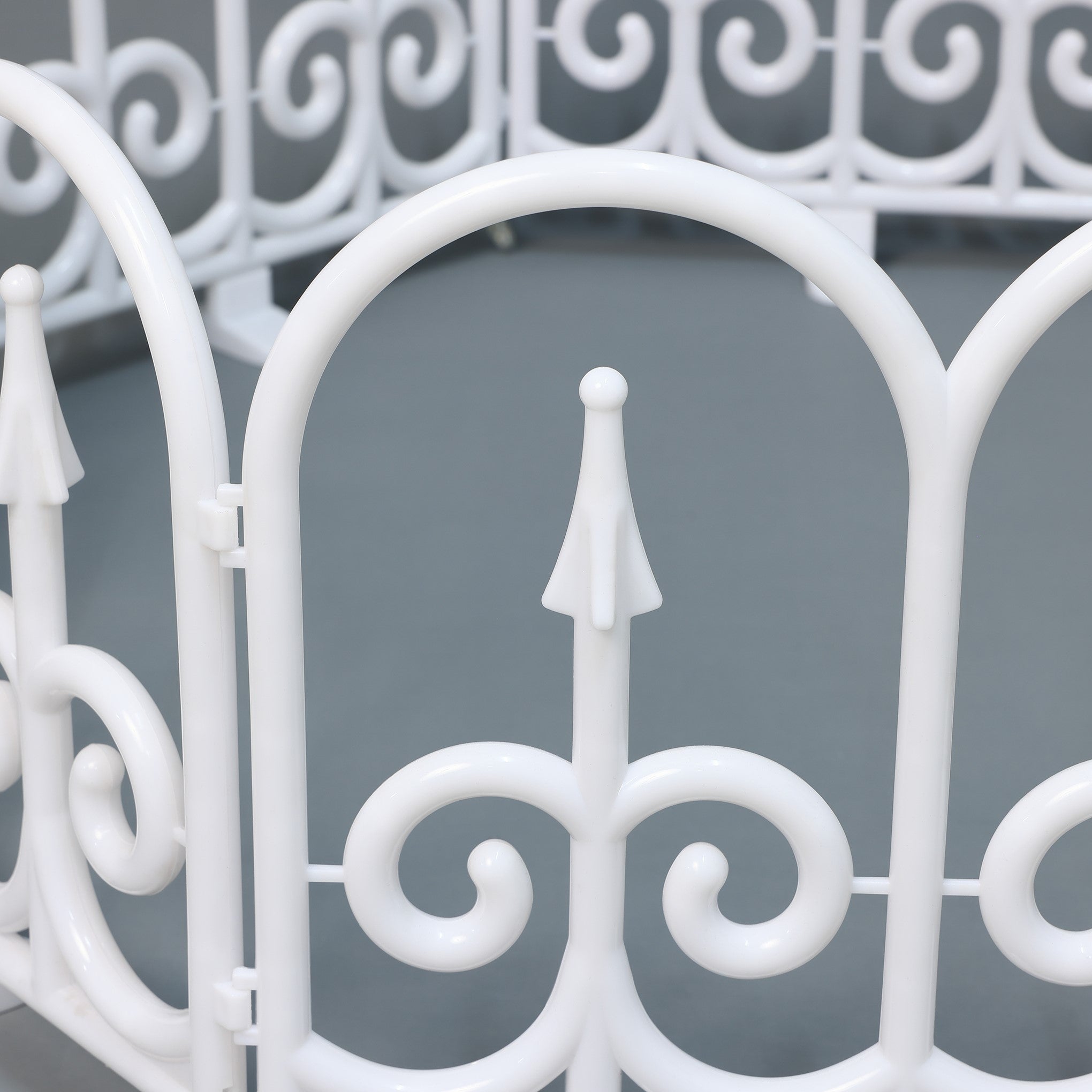 White metal led fence with decor scrollwork pointed finial, set against a plain gray background.
