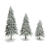 3 artificial pine trees of varying heights with realistic snow-flocked branches, standing on square base, against white background.