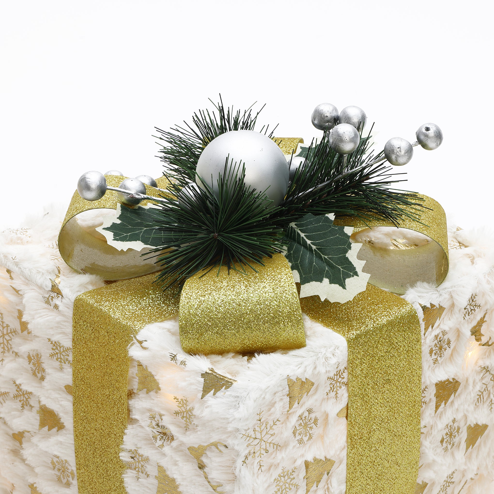 White gift box with gold snowflake ,tree patterns, gold ribbon, faux pine branches, holly leaves, silver ornaments
