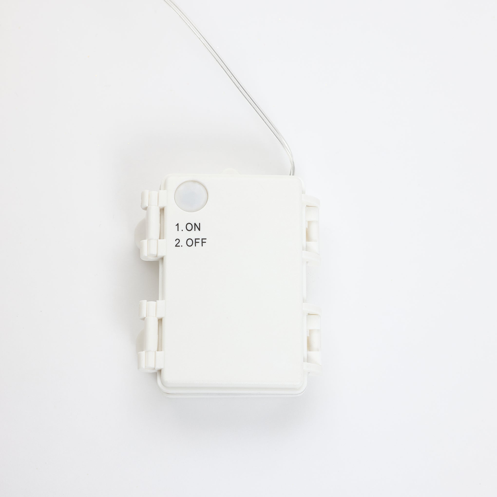 White rectangular plastic box with wire attached, featuring printed text that reads 1. ON 2. OFF on the frontns.