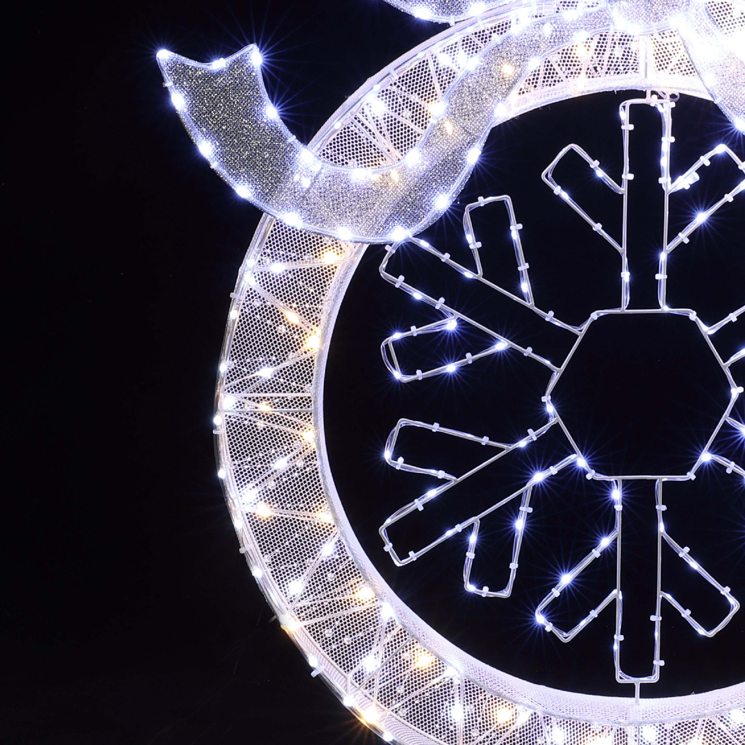 Close-up of illuminated snowflake decor with white led lights ,festive led wreath striking.