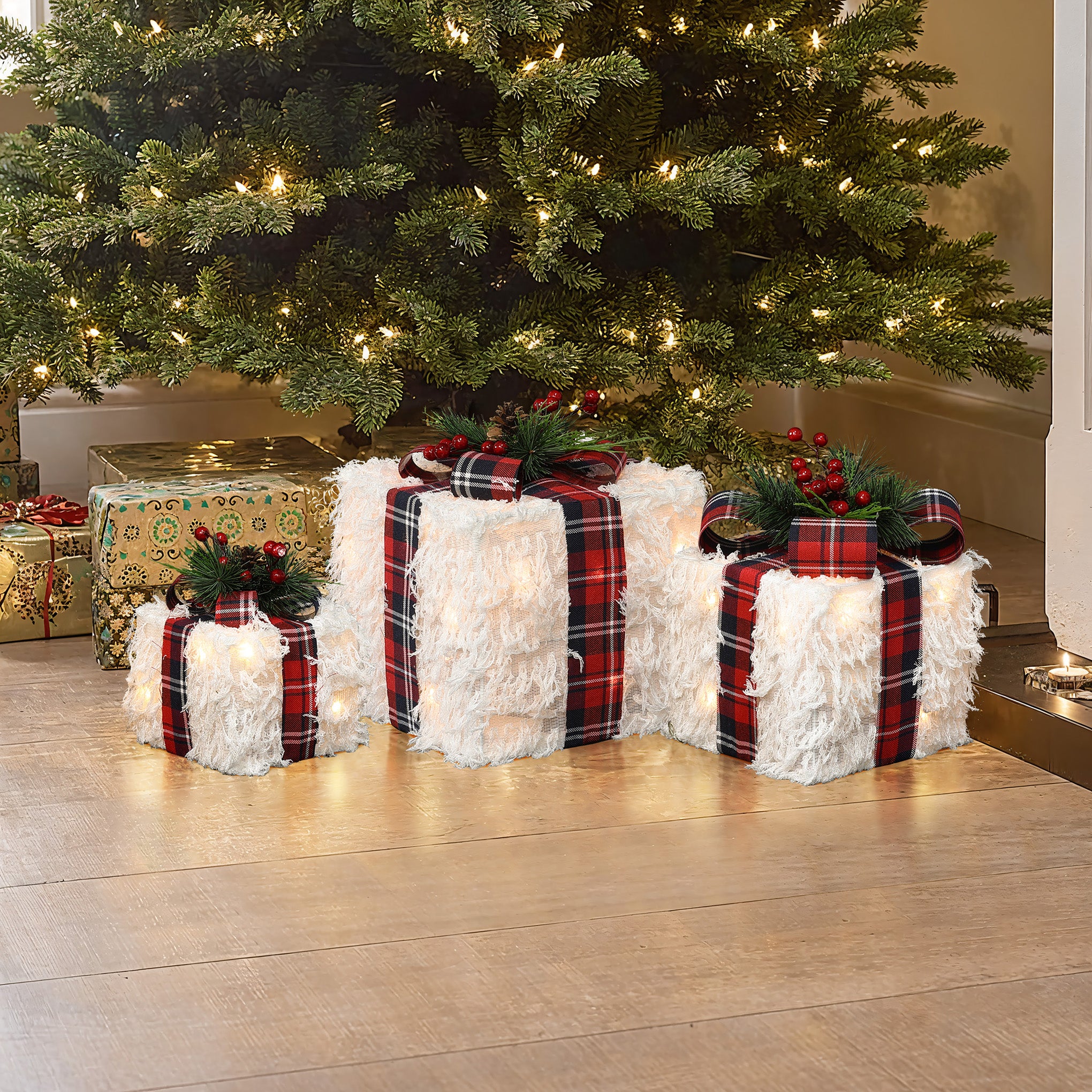 3 white, fluffy gift boxes with red plaid ribbons, decor christmas tree with lighted.