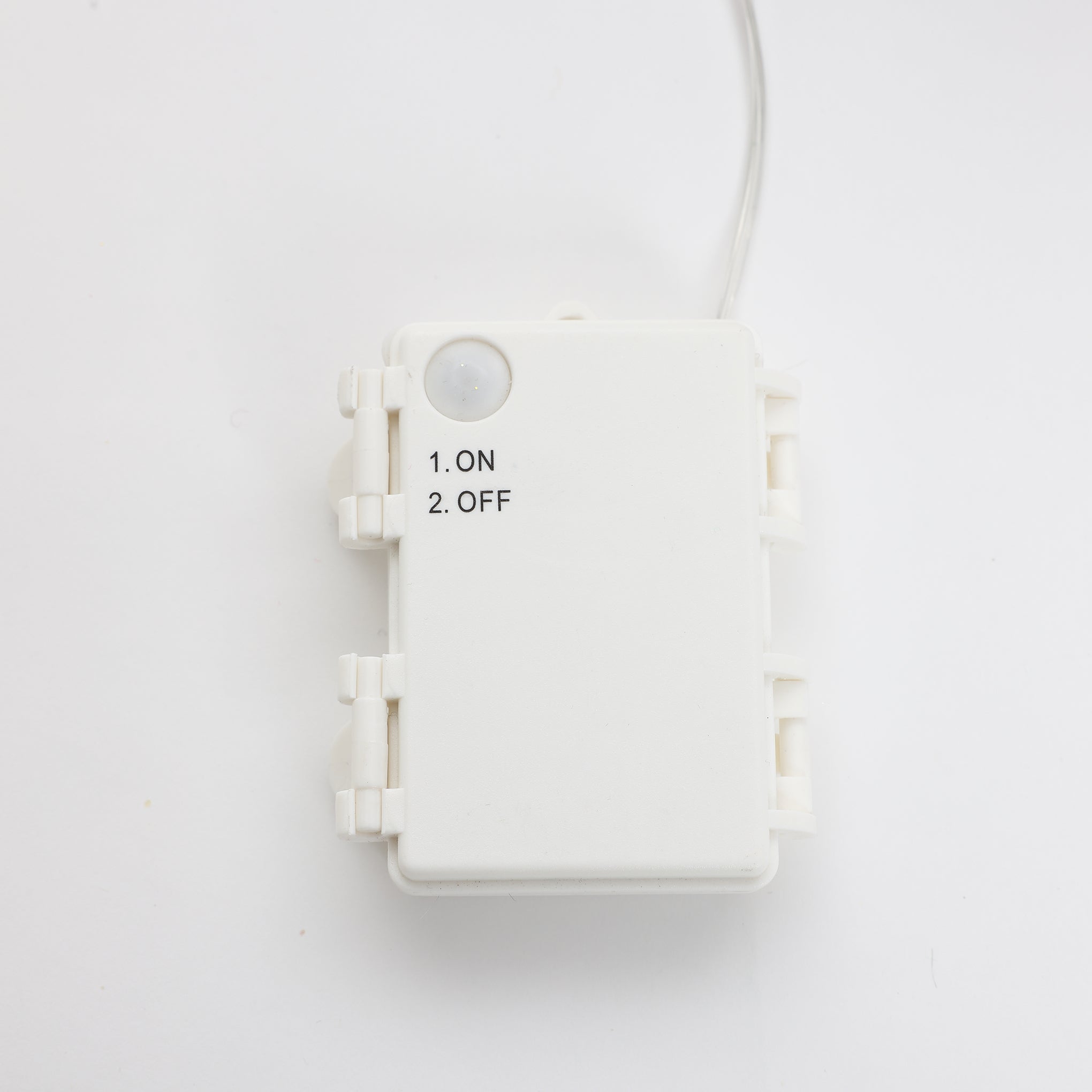 White plastic control box with small button, printed ON/OFF options. A single wire extends from the top.