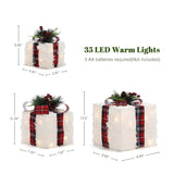 3 decor white faux-fur gift boxes with led lights, plaid ribbons ,greenery are shown in different sizes.