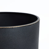 Close-up of a black, textured cylindrical container with a distressed black finish and a slightly worn rim on a white background.