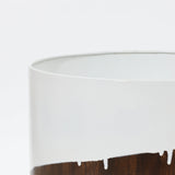 Close-up of a white cylindrical container with a glossy brown base and a clean edge, creating a unique dynamic visual effect against a plain background.