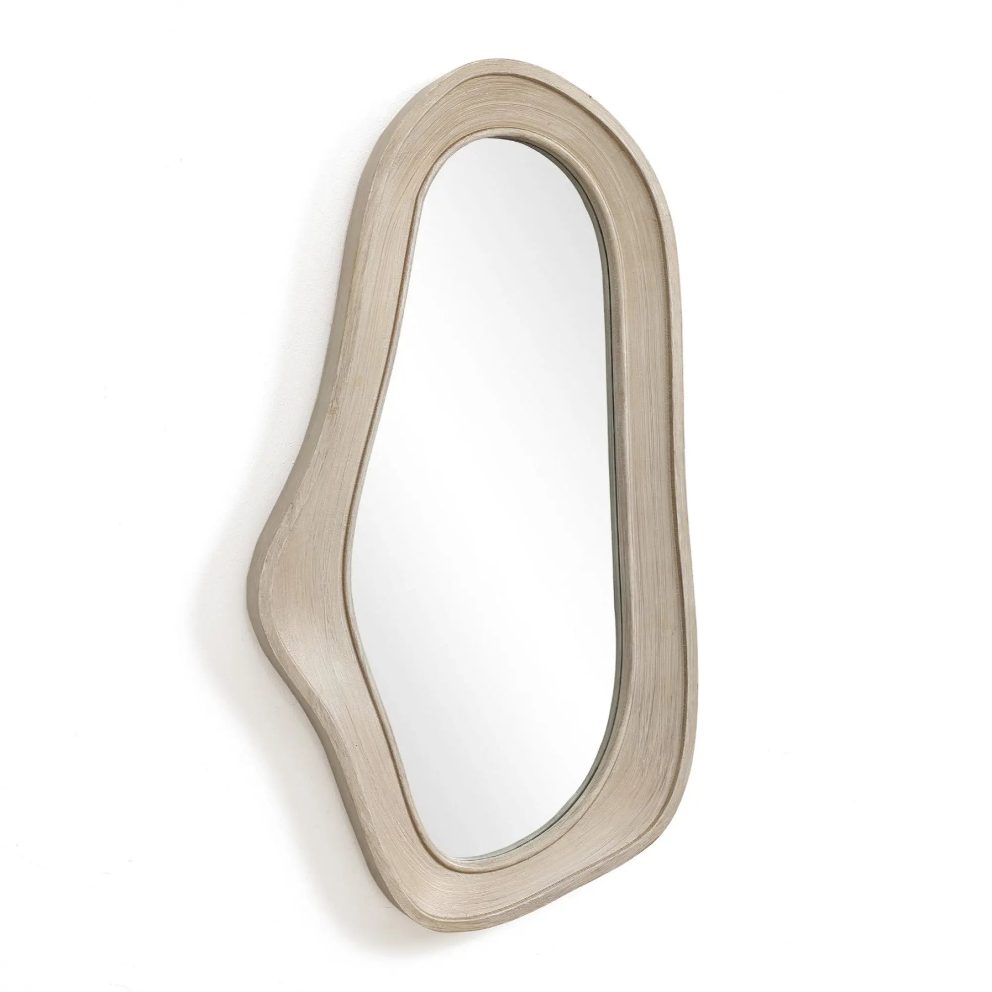 An oval irregularly shaped wall mirror with a natural finish wood frame hangs elegantly on a white wall, adding a touch of modern home decor.