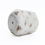 A used paint roller, embodying a vintage minimalist style, is covered in white and brown splatters against a plain white backdrop.