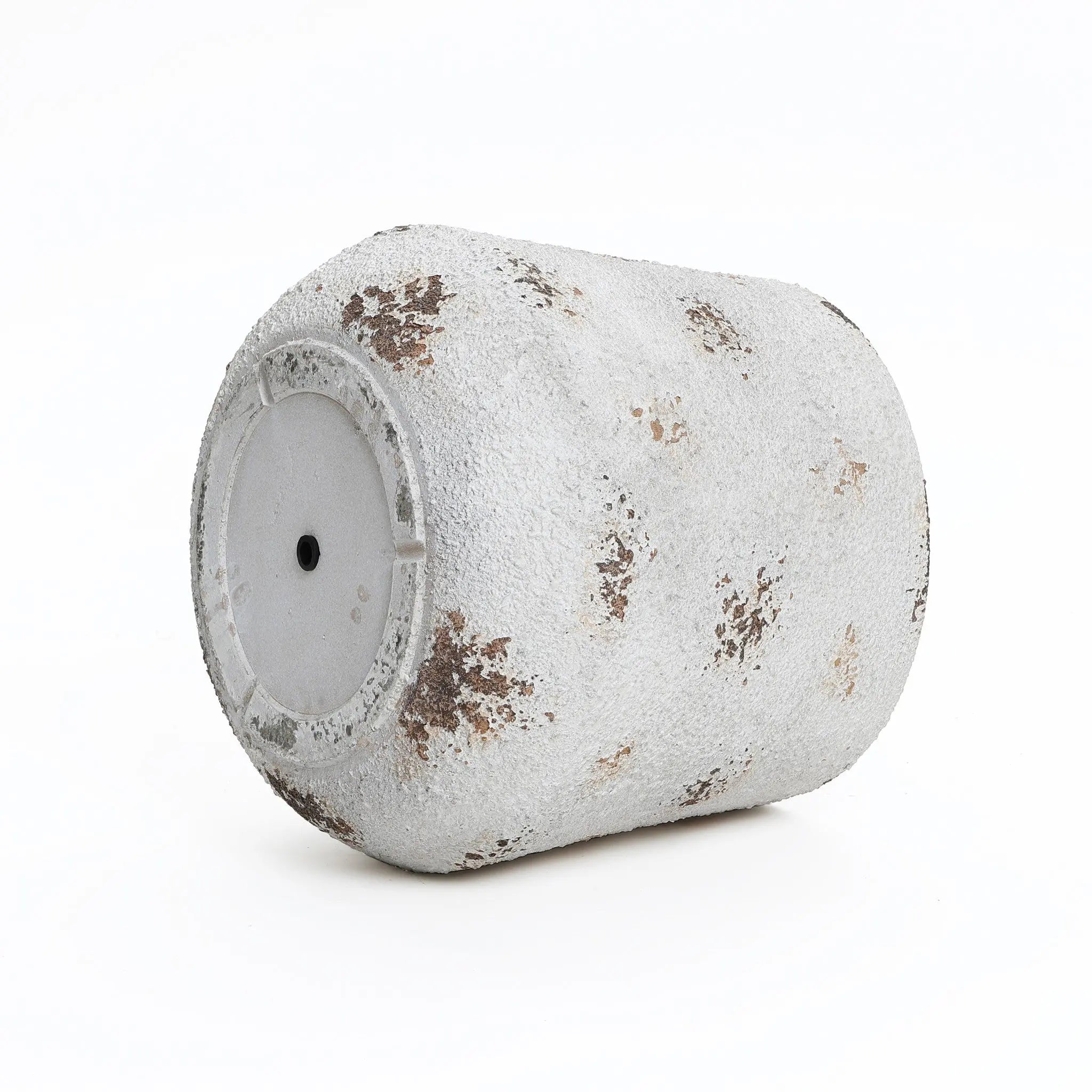 A used paint roller, embodying a vintage minimalist style, is covered in white and brown splatters against a plain white backdrop.