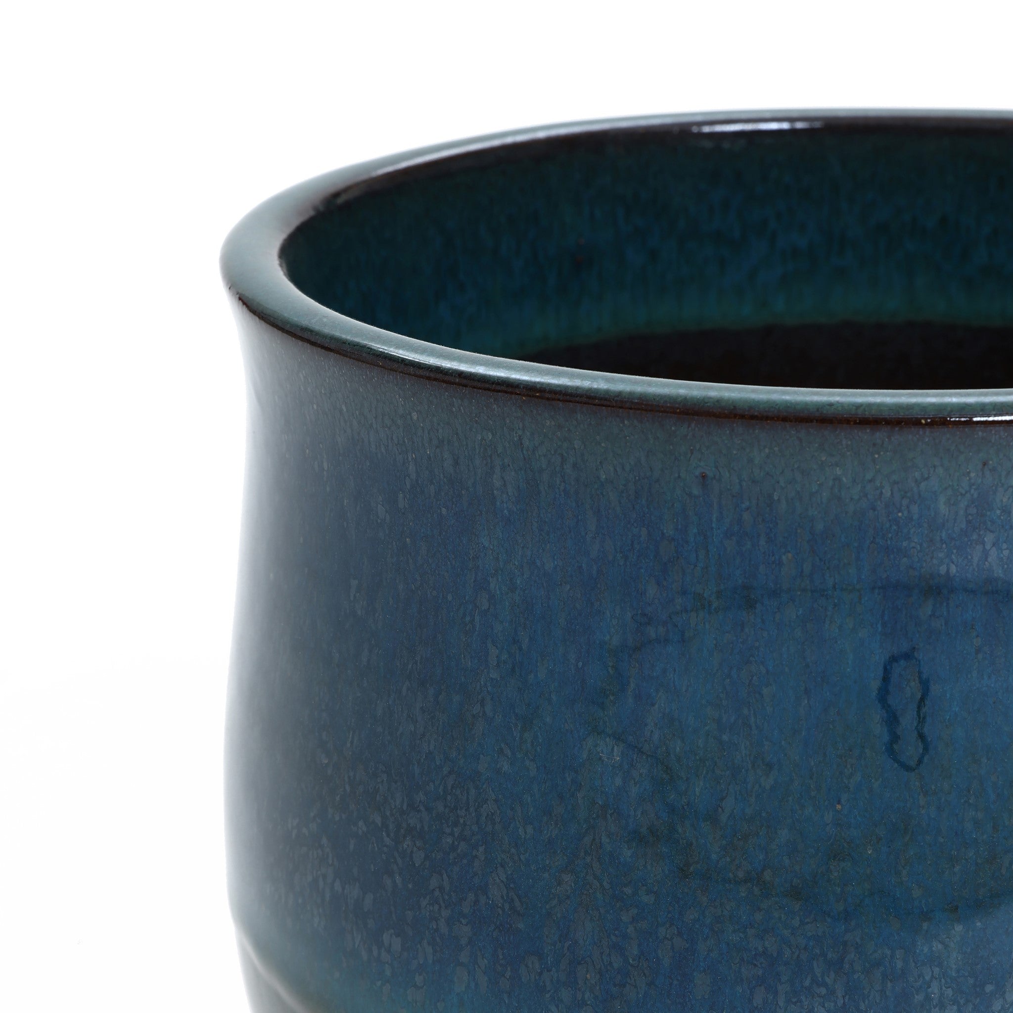 Close-up of a blue ceramic planter with a smooth surface and a slightly flared rim. The glaze has a textured, mottled appearance, making it an exquisite decorative piece for any space.