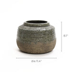 The LuxenHome Rustic brown stoneware bowl vase features a textured surface with a ribbed, dark green upper section and a rough natural brown lower finish. Ideal for home decor, this pot measures 8.1 inches tall and 11.4 inches in diameter.