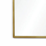 A close-up view of the LuxenHome Rêverie vintage gold accent metal frame arch mirror. The photo highlights the top left corner against a plain white wall, exuding understated elegance reminiscent of an arched window silhouette.
