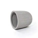 A gray, ribbed, cylindrical concrete planter with a modern striped pattern lies on its side against a white background, perfect for adding a contemporary touch to your home and garden.