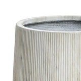 Close-up of a textured, cylindrical light gray concrete planter with vertical grooves, featuring a drainage hole for optimal plant health.