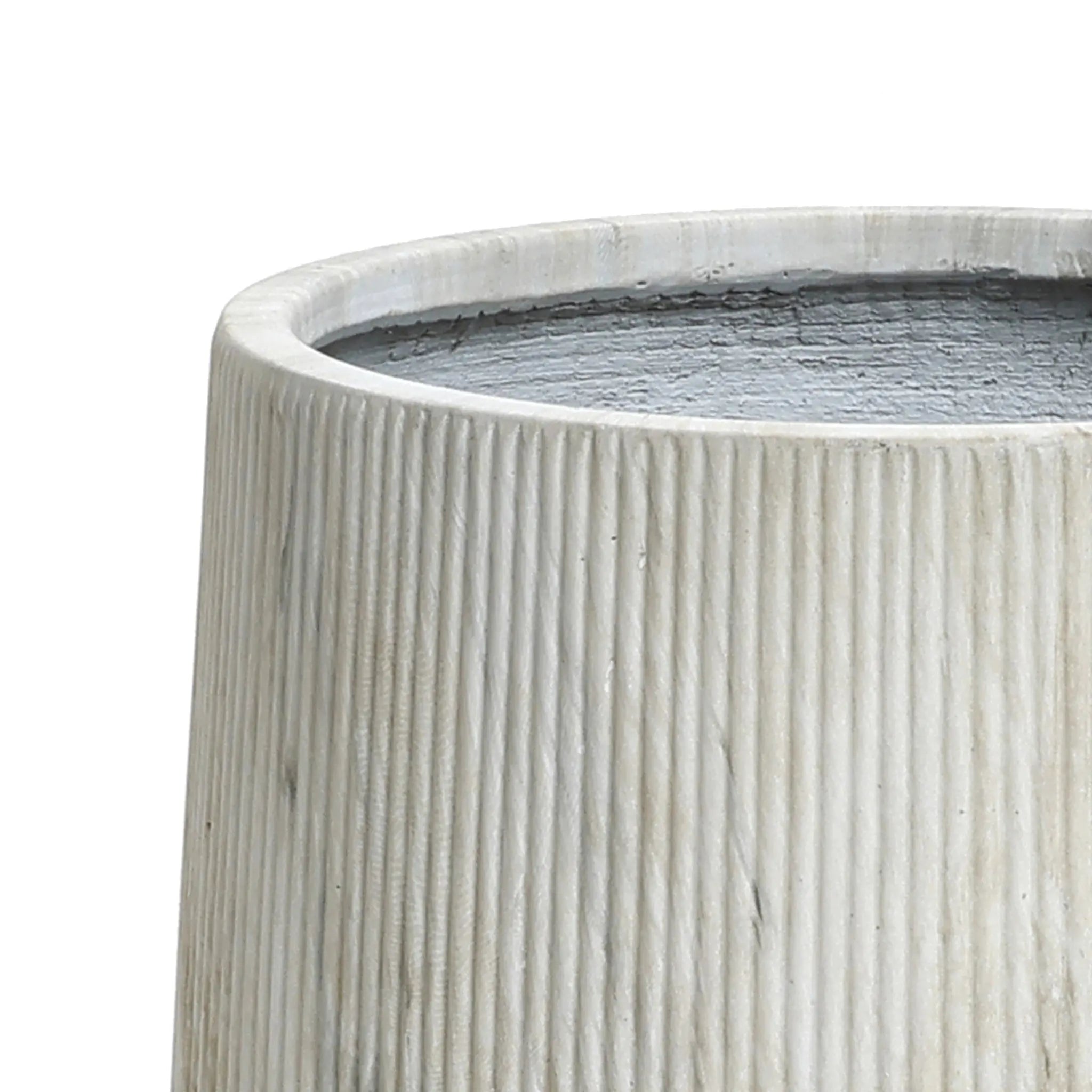 Close-up of a textured, cylindrical light gray concrete planter with vertical grooves, featuring a drainage hole for optimal plant health.