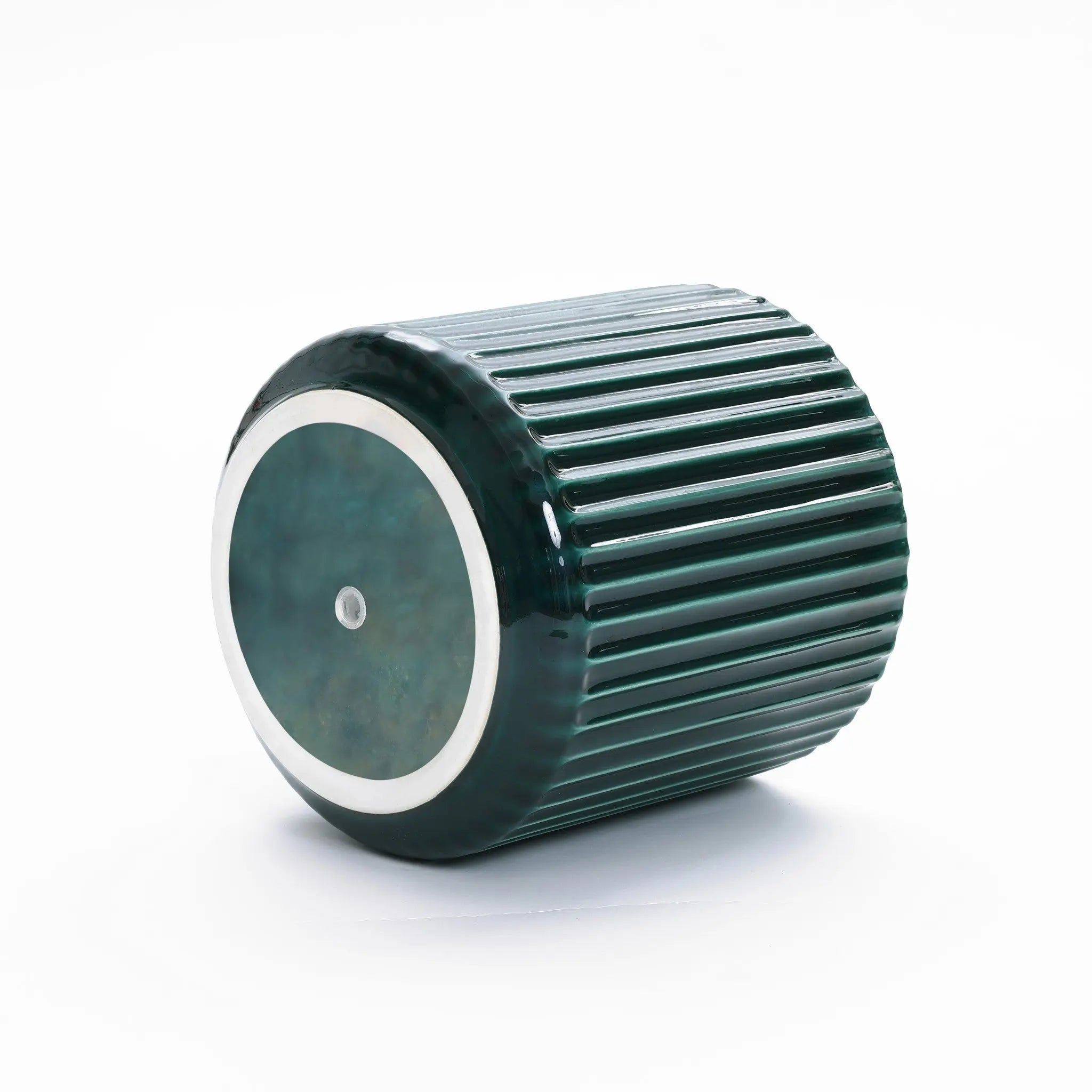 The LuxenHome Jade green ribbed glazed ceramic planter, 13 h, lies gracefully on its side against a white background. Its cylindrical design features a reflective circular end with a metallic dot, giving it a modern plant paradise vibe.