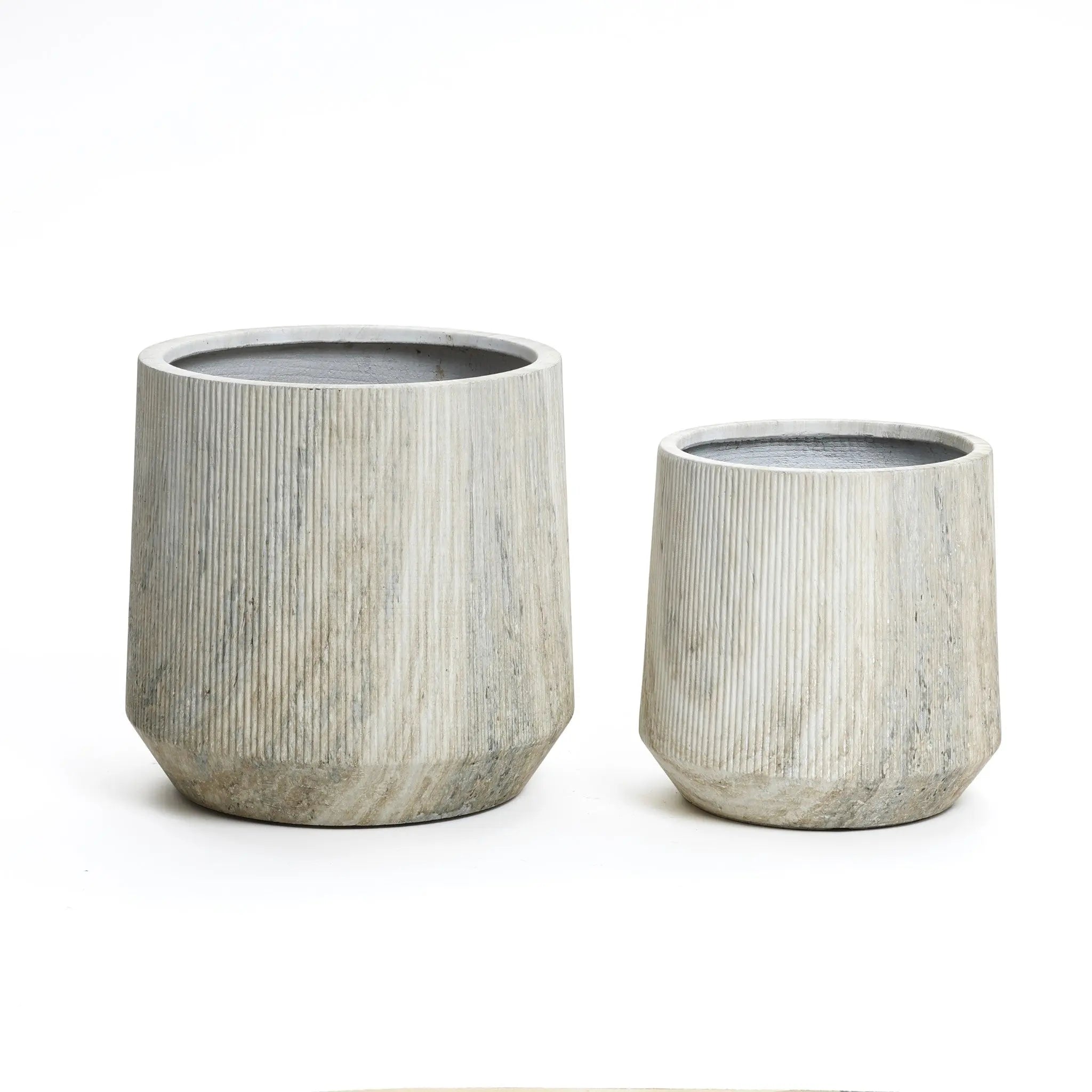 A stylish planter set features two ribbed, cylindrical stone planters of differing sizes, placed side by side against a white background. Each boasts a unique marble ribbed texture and comes with a drainage hole for optimal plant care.