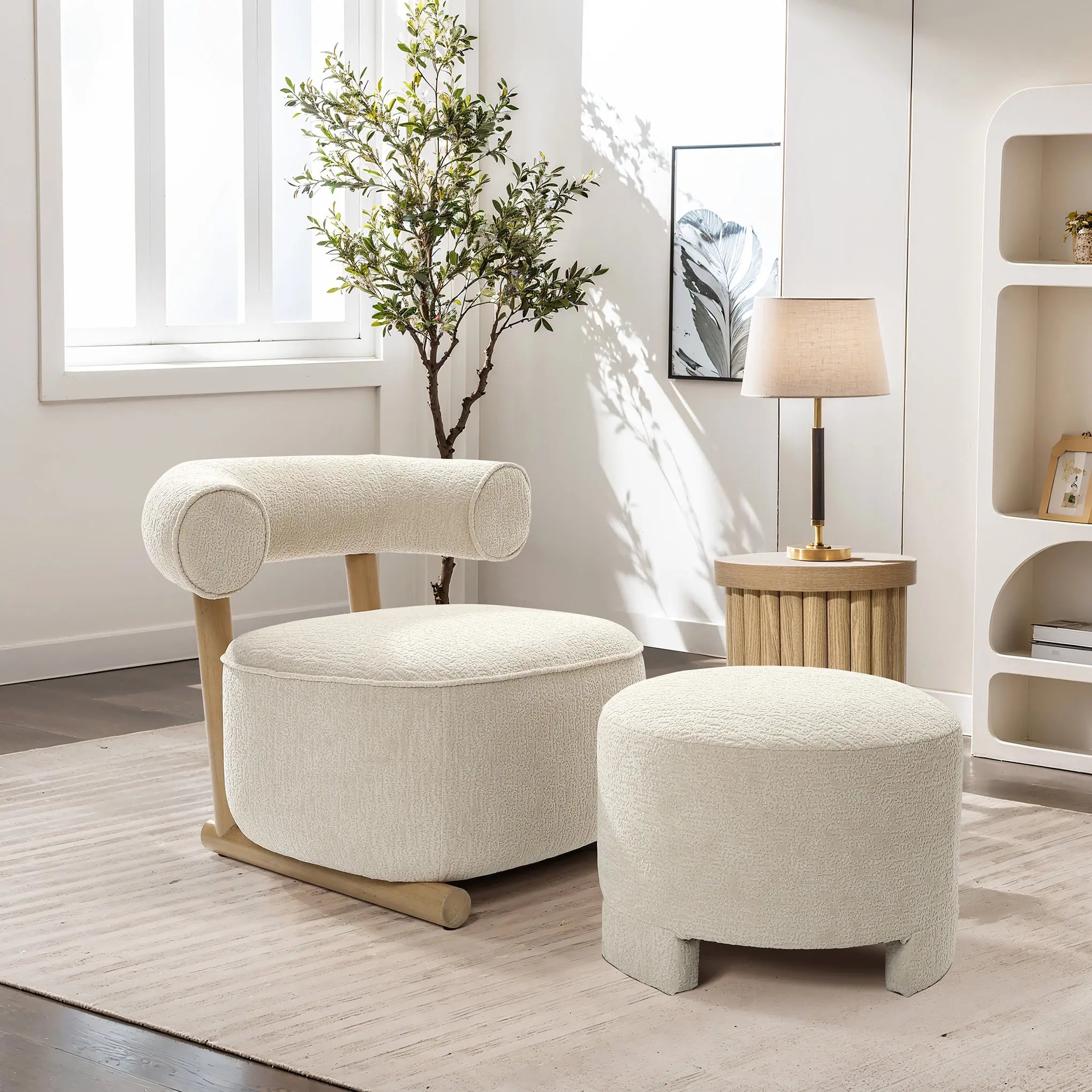 A cozy living room showcases a LuxenHome Rio upholstered cream accent chair with a matching ottoman on a light rug. A wooden side table holds a lamp, accompanied by a leafy plant. Large windows and shelves with decor complete the contemporary space.